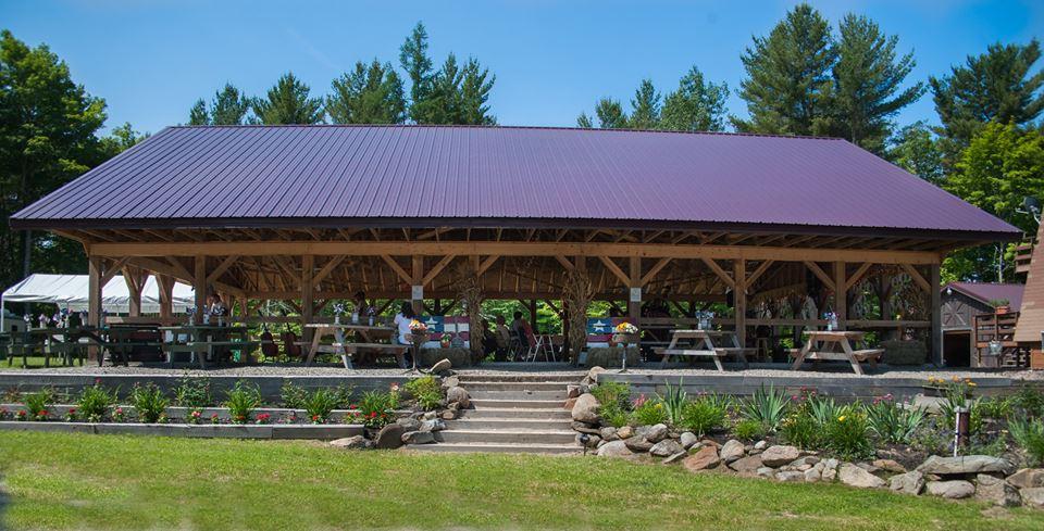 Campers at a bean-hole dinner with live bluegrass under the pavilion